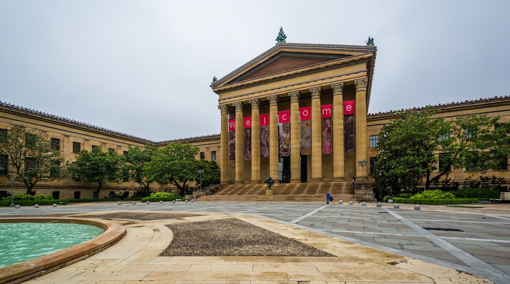 A classical building with columns and a 'Welcome' banner.