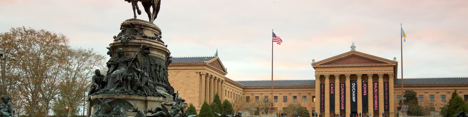 A statue of a man on horseback in front of a museum with classical architecture.