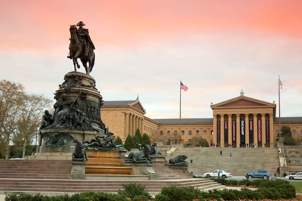 Eine Statue eines Mannes zu Pferde vor einem Museum mit klassizistischer Architektur.