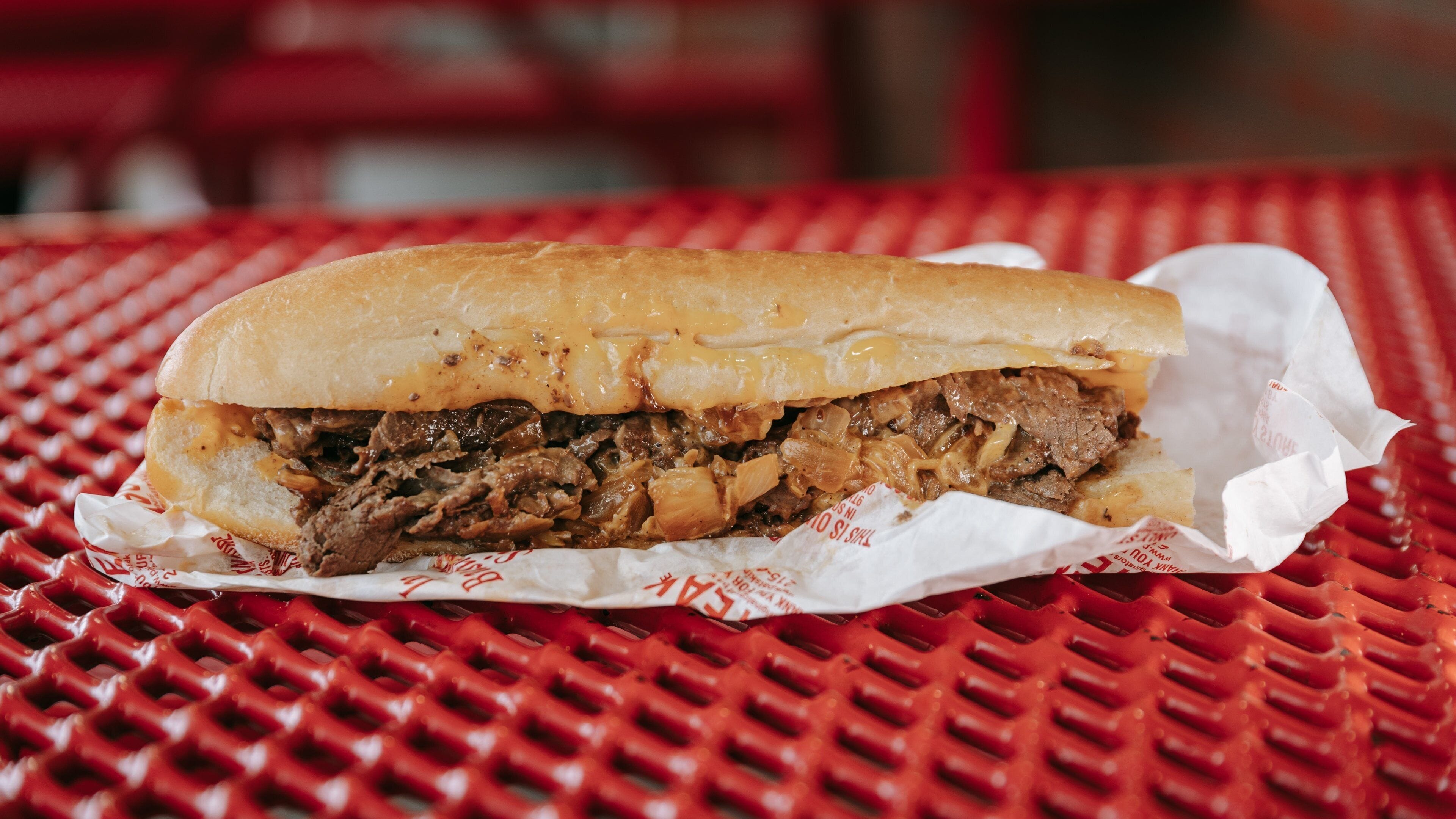 A sandwich on a red plastic table.