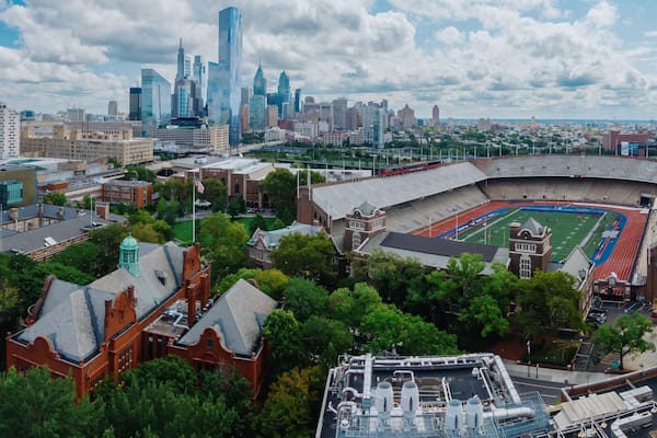 Ein Stadion, umgeben von historischen Gebäuden und einer modernen Stadtansicht.