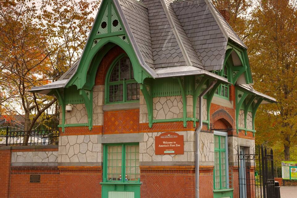 Edifici històric amb maó verd i vermell, finestres allargassades i un cartell que diu "Welcome to America's First Zoo".