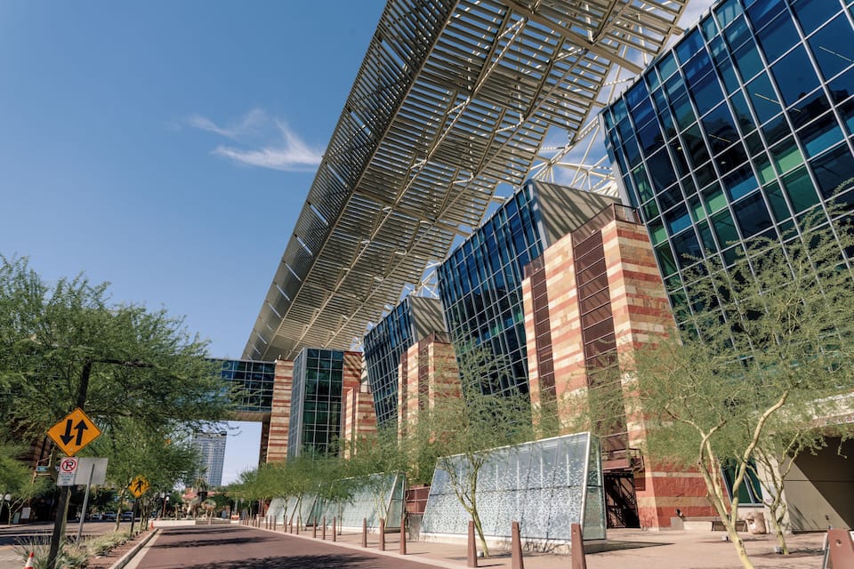 A modern building with a glass facade and a metal roof structure.