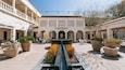 A courtyard with a fountain, potted plants, outdoor seating, and the entrance to the Heard Museum.