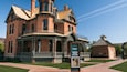 Un musée installé dans une maison historique, dotée d’un porche imposant et d’une enseigne.