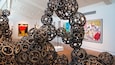 Una galería de arte con esculturas y pinturas abstractas.