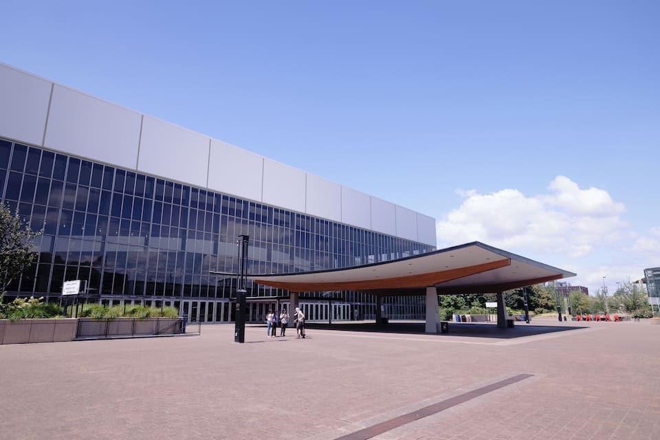 A modern building with a glass facade and a covered entrance area.
