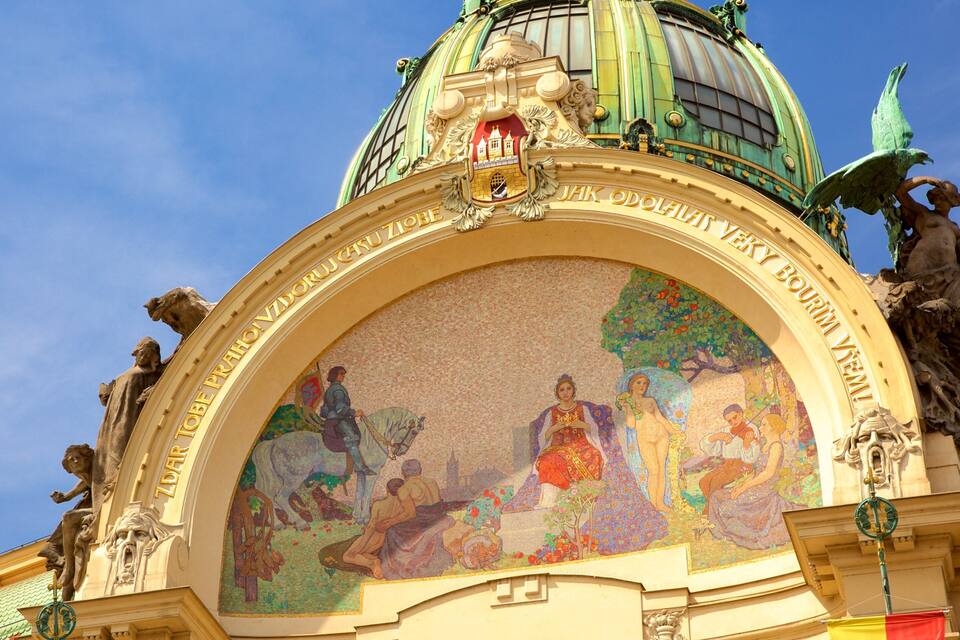 A mosaic mural on a building's facade with classical sculptures and a dome.