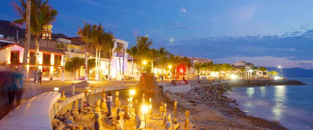 Malecon showing night scenes, a coastal town and a sandy beach