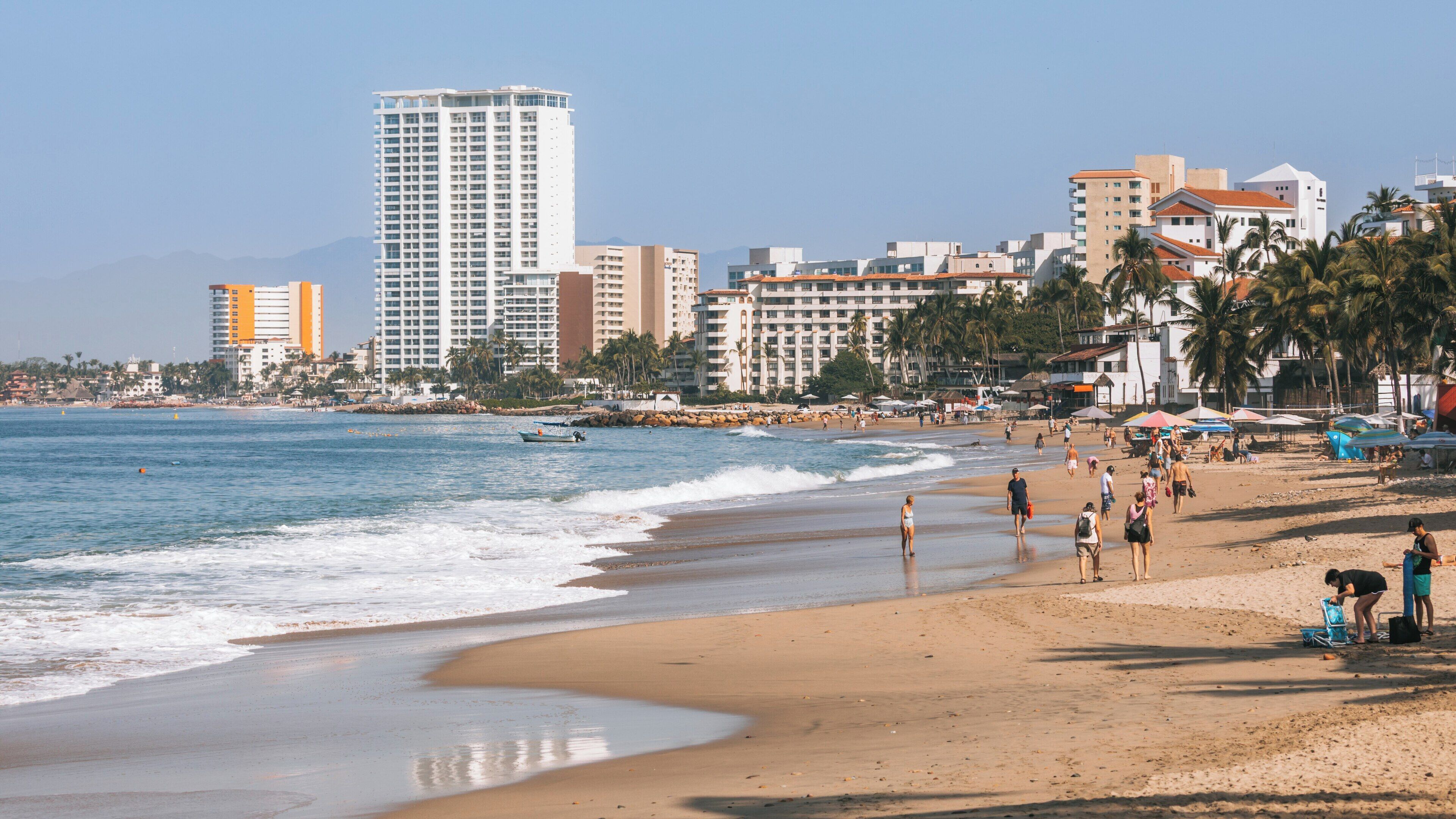 Visitors stroll along the sandy shores of Malecon in Downtown Puerto Vallarta on a sunny day in Jalisco, Mexico