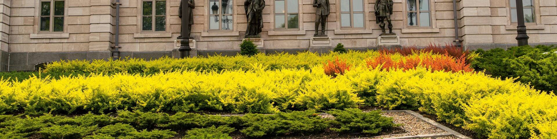 Parliament Building showing a statue or sculpture, a garden and heritage elements