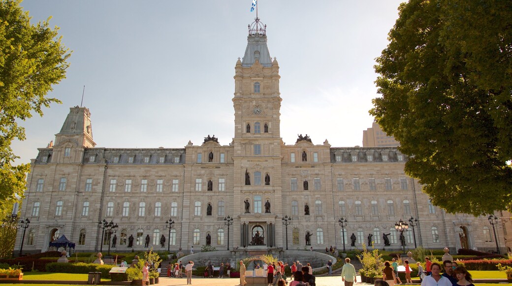 Parliament Building featuring heritage architecture and a sunset as well as a small group of people