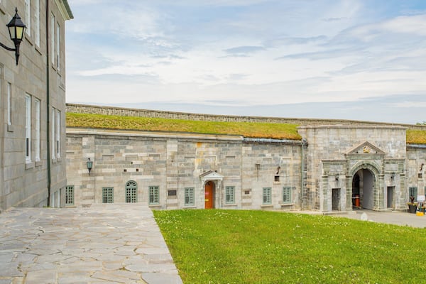 Ein historisches Steinhaus mit grünen Fenstern und einem grünen Innenhof.