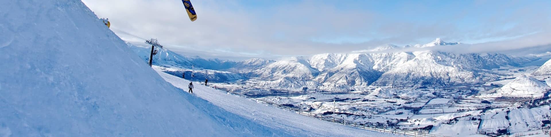 Estación de esquí Coronet Peak ofreciendo esquiar en la nieve y también un pequeño grupo de personas