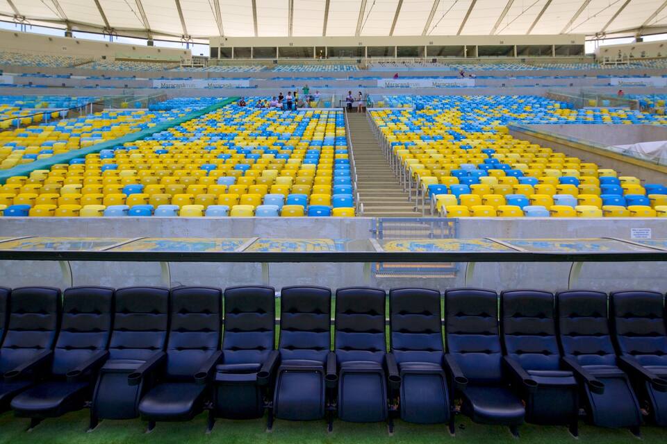 An empty stadium with blue and yellow seats and a central walkway.