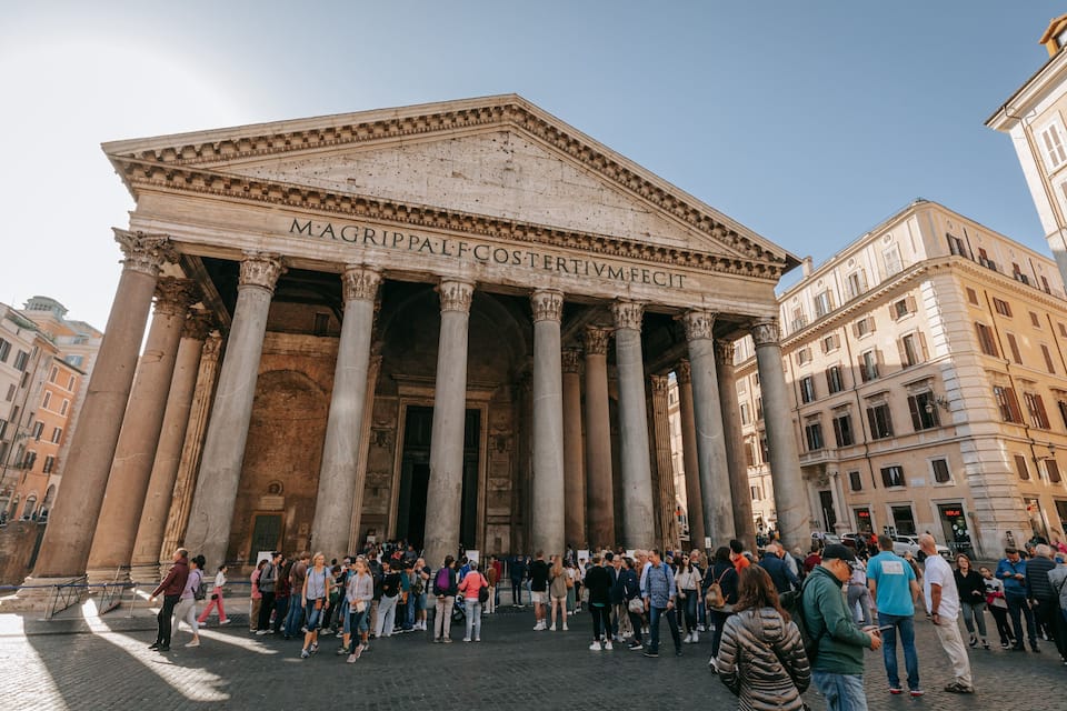 A large neoclassical building with columns and the inscription "MAGRIPPA COSTERTIVI".