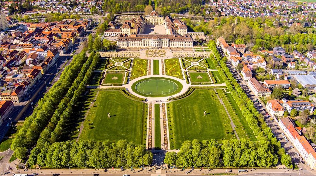 An aerial view of a historic palace with a large formal garden, surrounded by residential buildings.