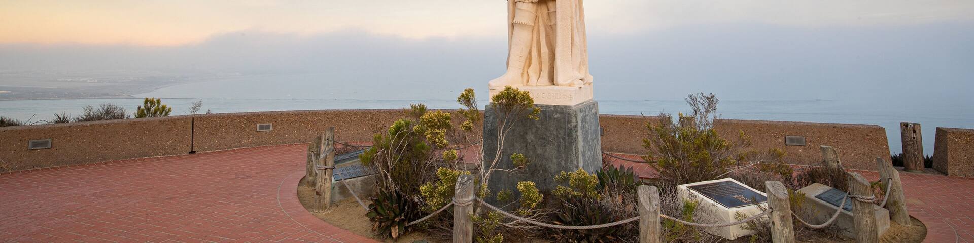 Cabrillo National Monument featuring a sunset, religious aspects and a statue or sculpture