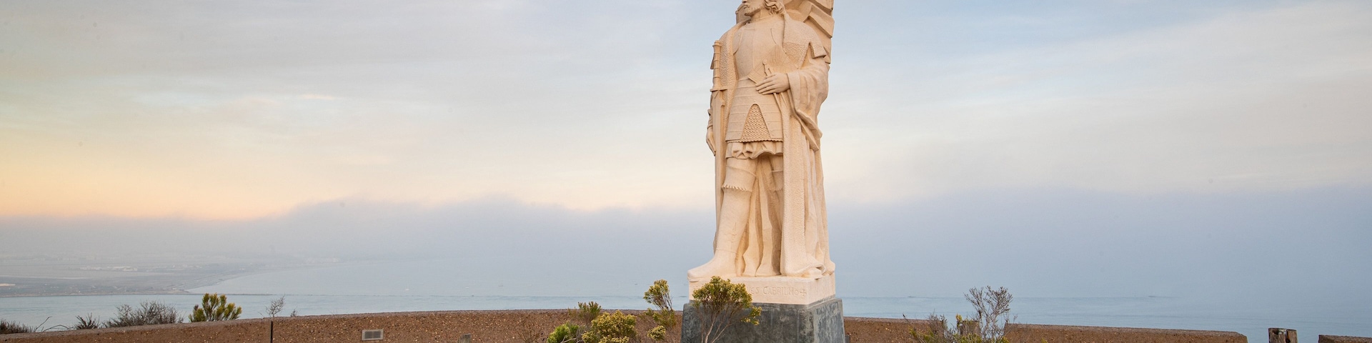 Cabrillo National Monument featuring a sunset, religious aspects and a statue or sculpture