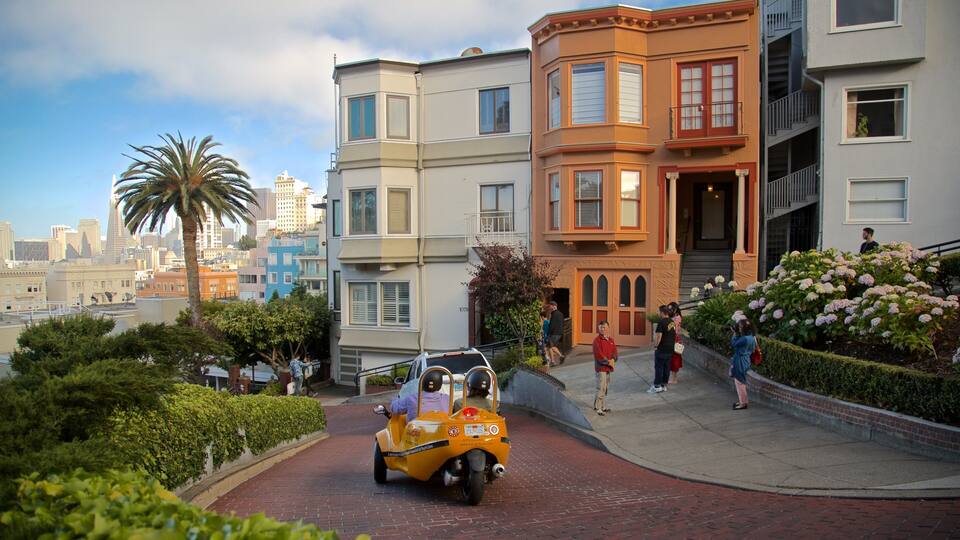 A yellow scooter with a driver and passenger, a palm tree, and a cityscape with multi-story buildings.