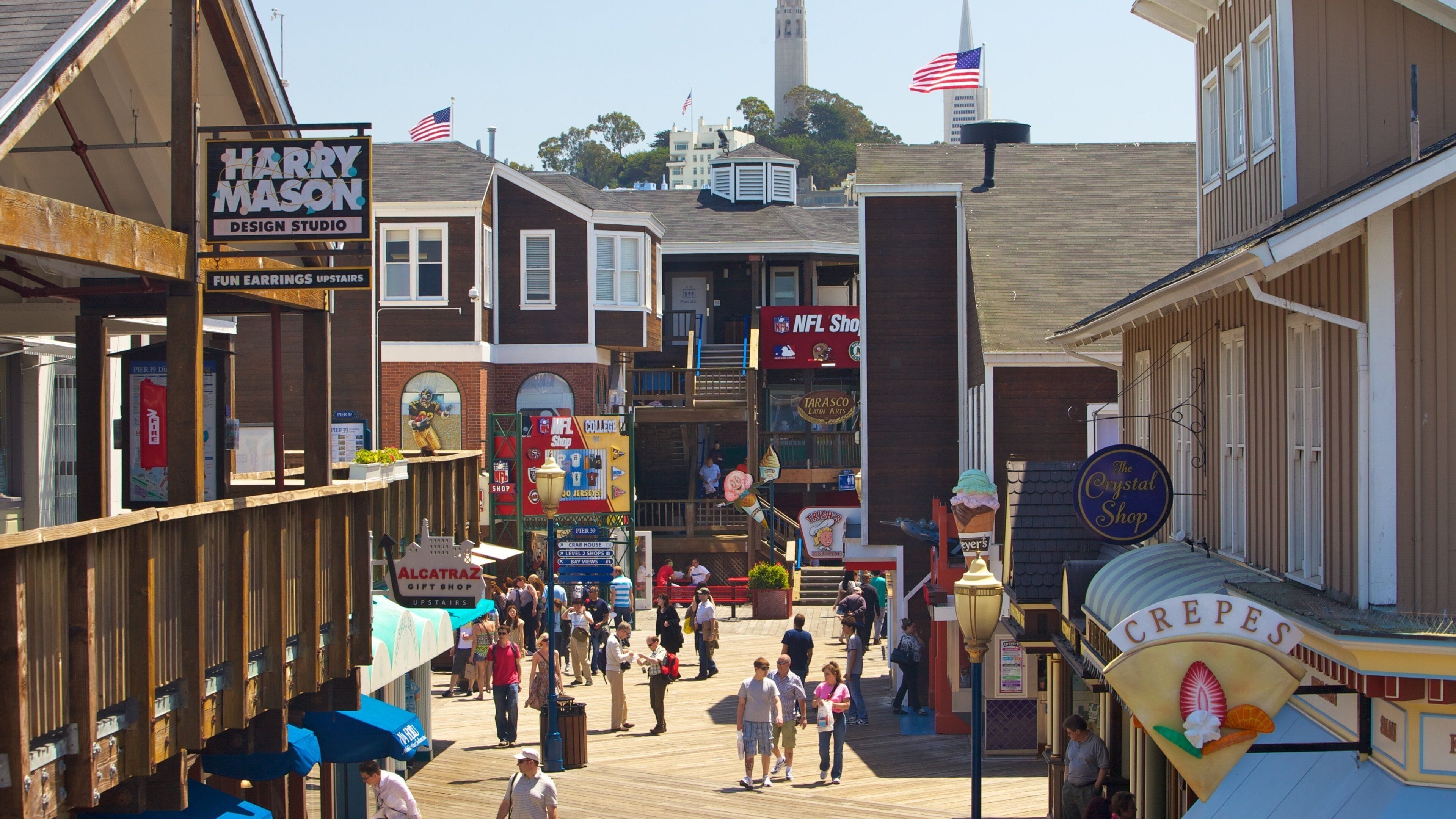 Exploring the vibrant boardwalk at Pier 39 in San Francisco with shops, food, and crowds enjoying the waterfront atmosphere