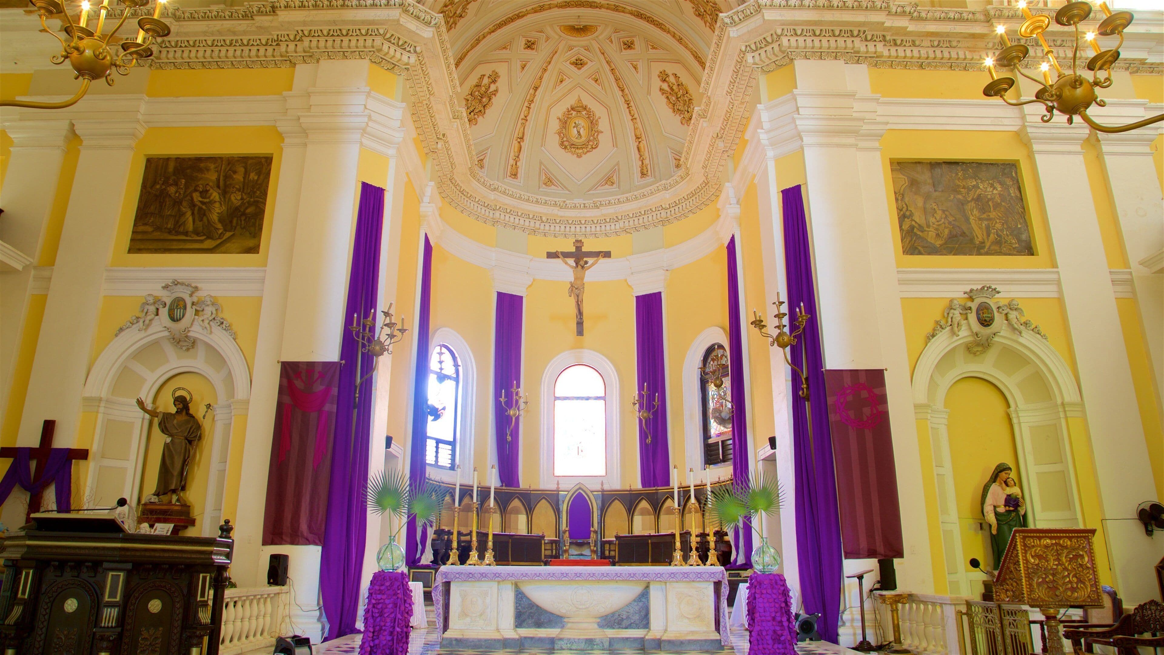L'intérieur d'une église avec un crucifix, un autel et des statues.
