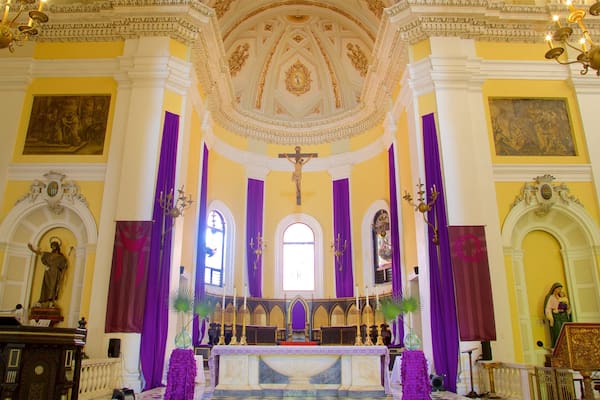 L'intérieur d'une église avec un crucifix, un autel et des statues.