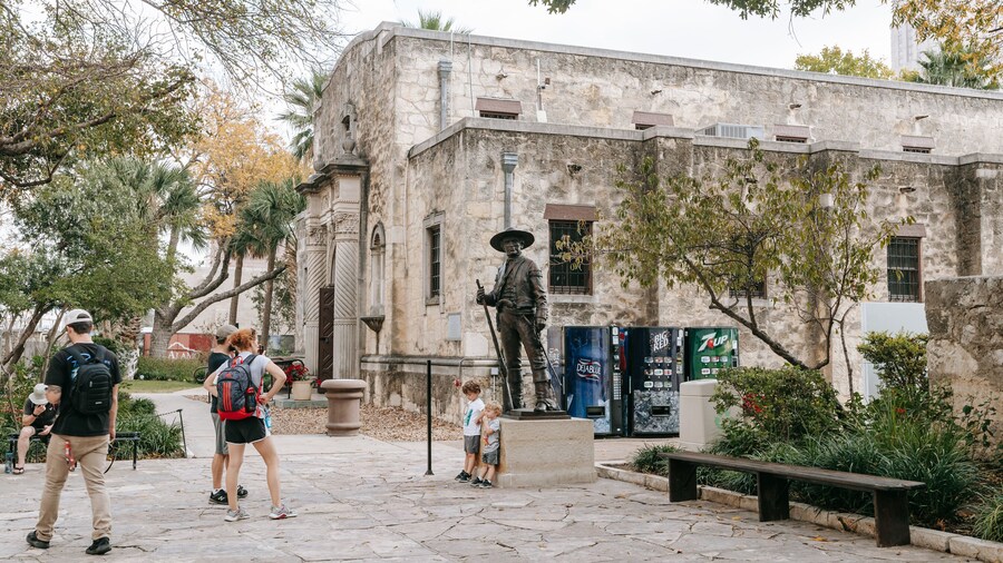 Alamo featuring a statue or sculpture and heritage elements as well as a family