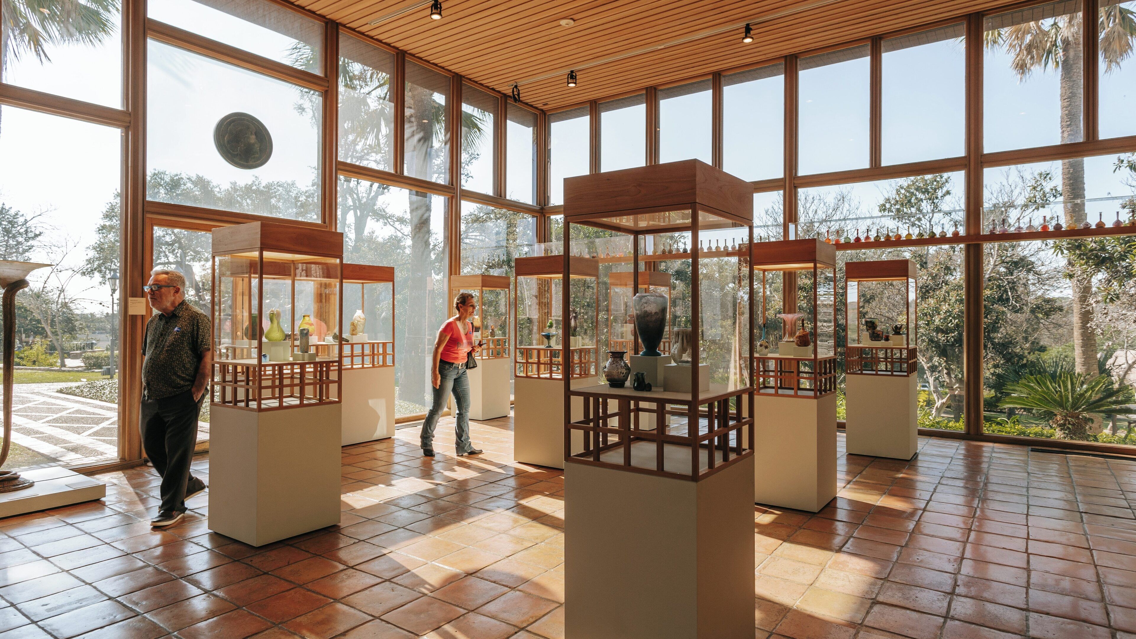 Visitors explore art exhibits at Marion Koogler McNay Art Museum in North San Antonio showcasing various sculptures and artifacts in a bright and open gallery space