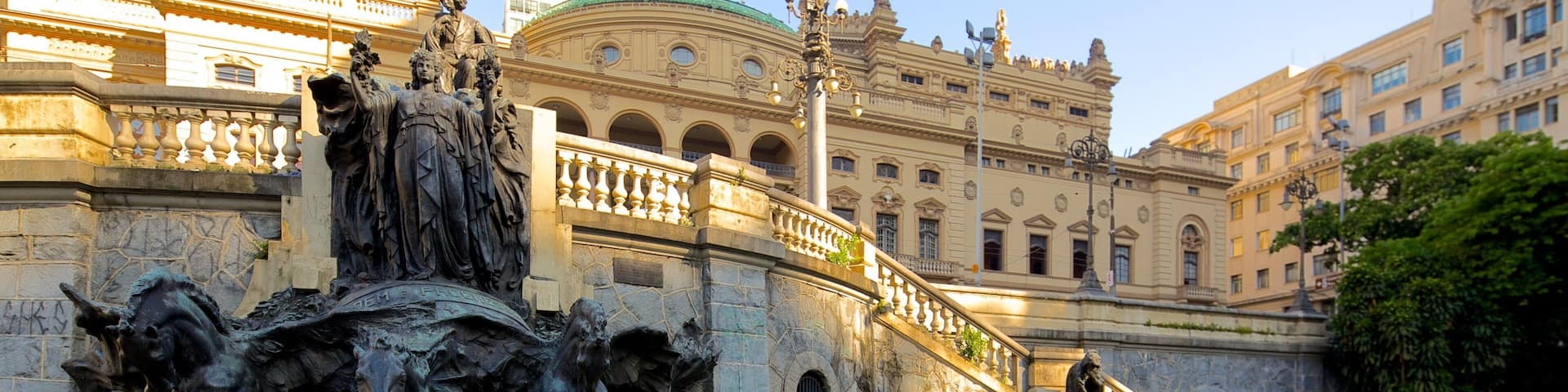 A bronze equestrian statue with a fountain in front, set against a historic building with classical architecture.