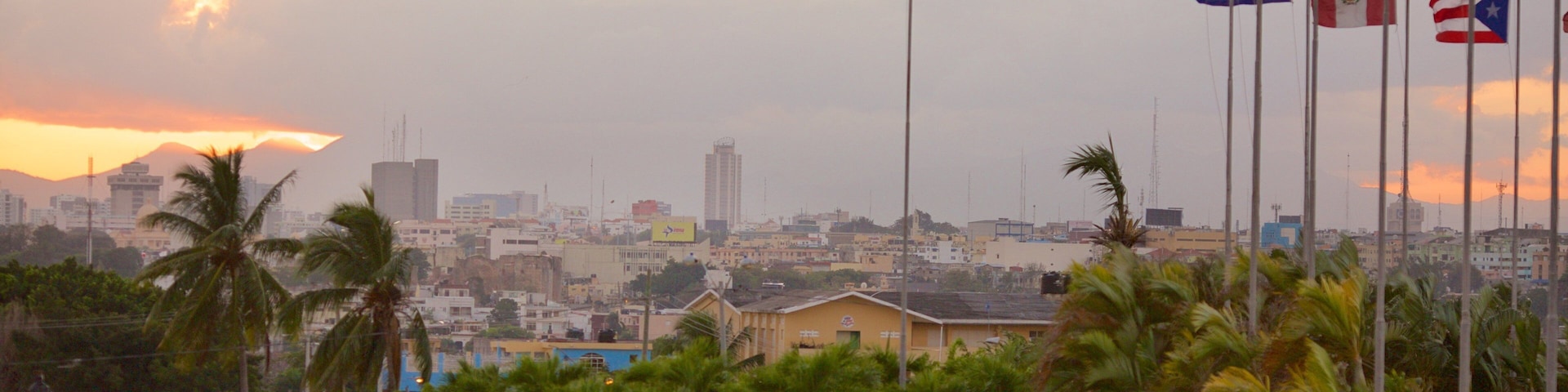 Columbus Lighthouse showing a sunset and a city