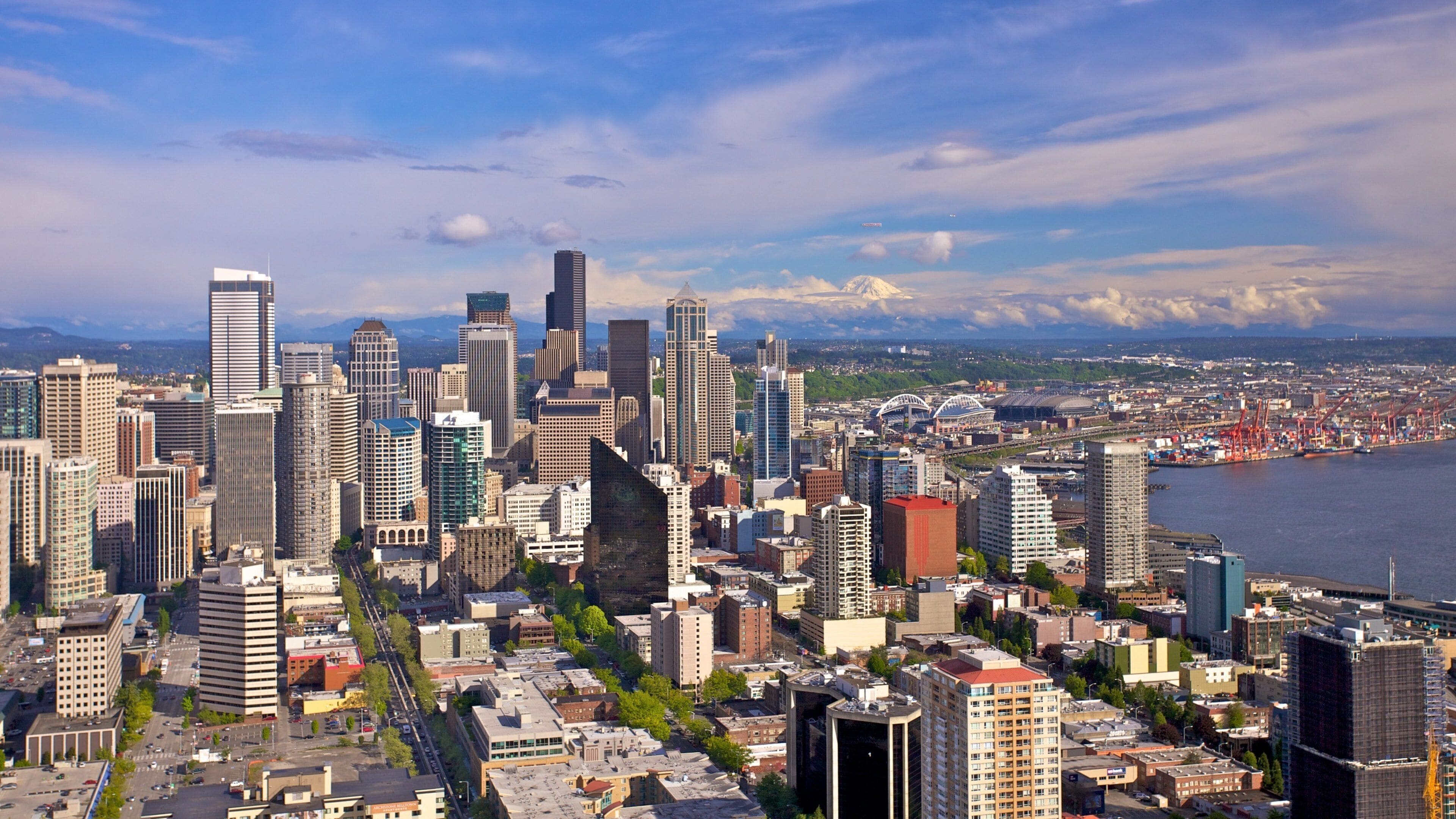 Iconic Space Needle rises above Seattle skyline under clear blue skies showcasing urban beauty