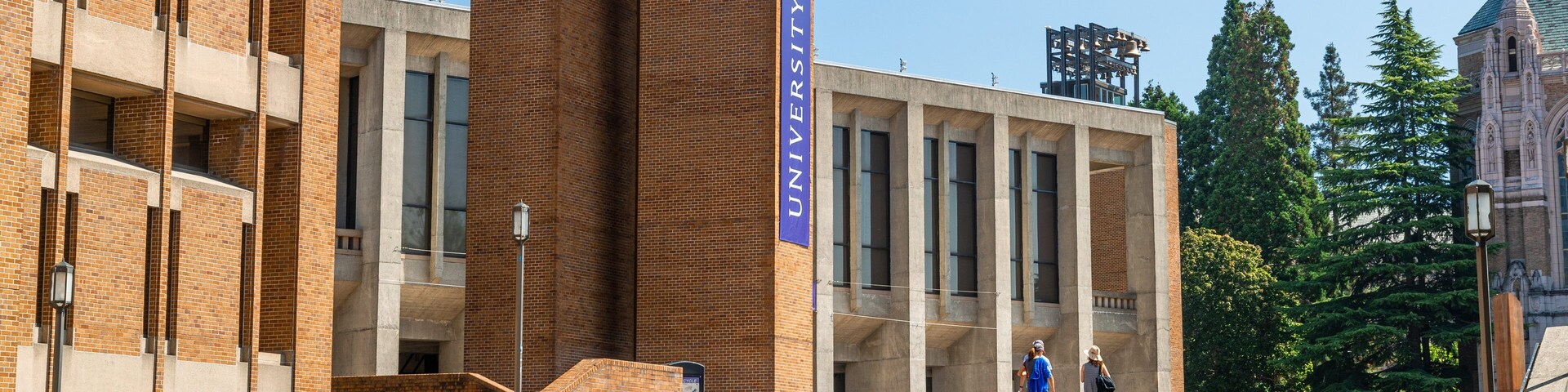 Un edificio universitario con un llamativo cartel de 'University of Washington', arquitectura de ladrillo y una escalera que conduce a la entrada.