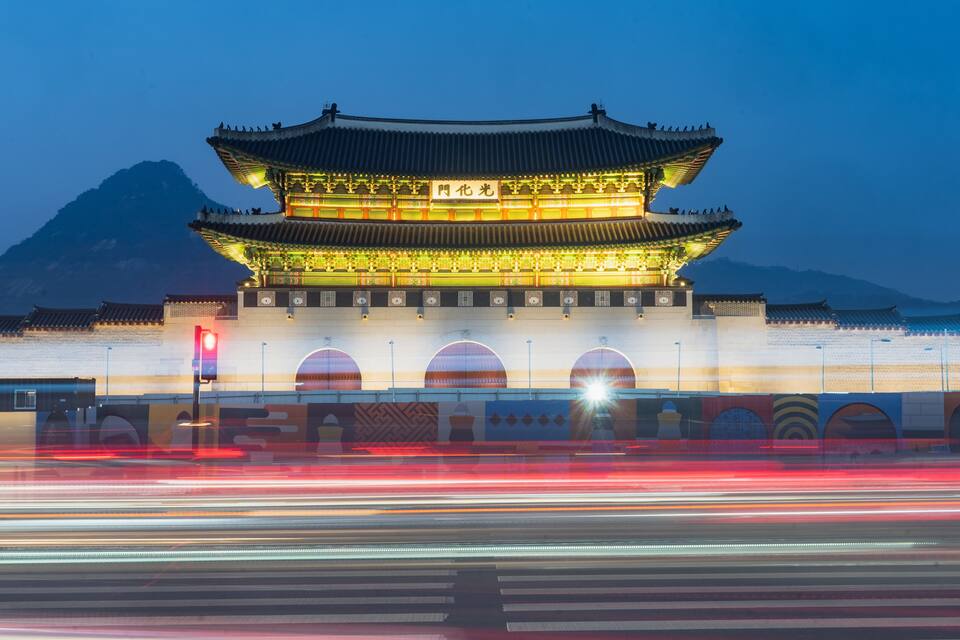 Um edifício tradicional chinês com telhado em vários níveis e interior iluminado ao entardecer.