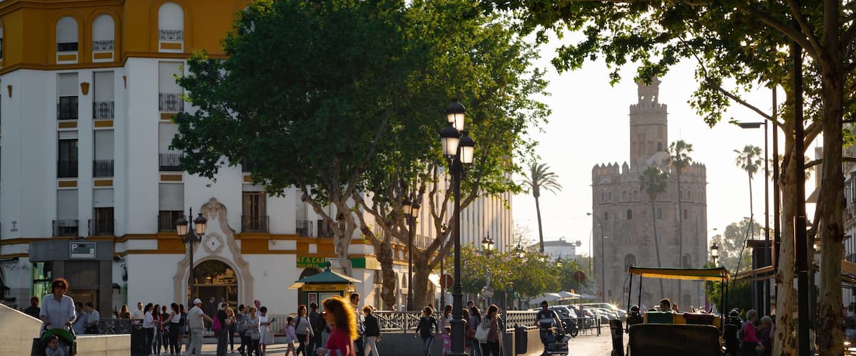 Torre del Oro Watchtower which includes a sunset and street scenes as well as an individual femail