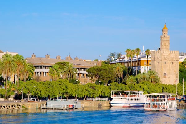 Torre del Oro Watchtower which includes a coastal town, heritage architecture and a marina