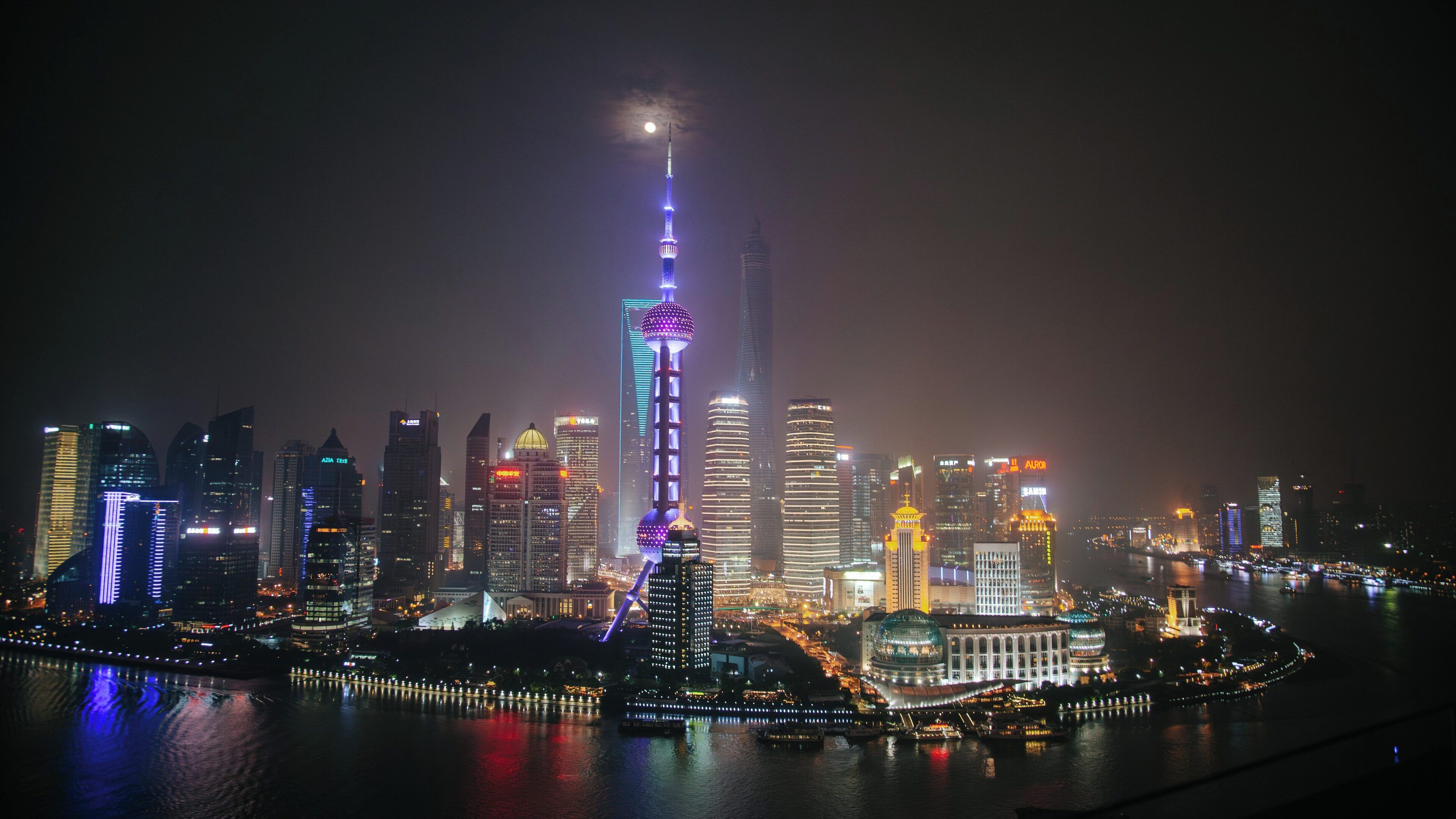 Illuminated Oriental Pearl Tower stands tall in the skyline of Pudong, Shanghai, showcasing modern architecture against the night sky