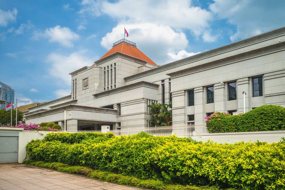 A modern building with a red roof and a flag on top.