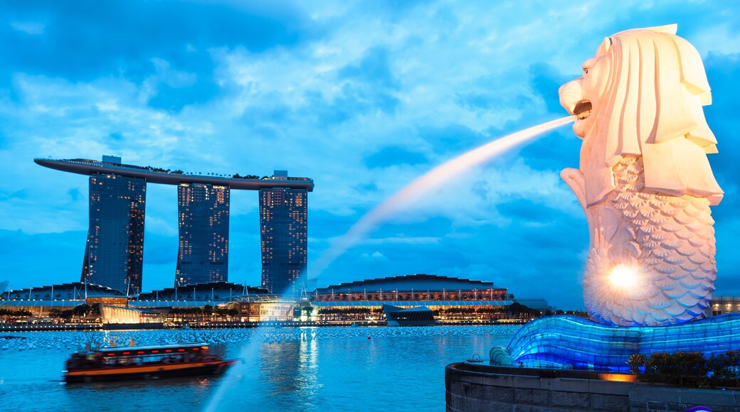 The Merlion fountain lit up at night in Singapore.