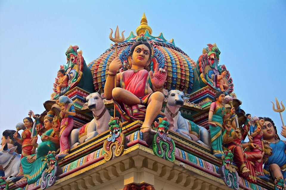Un temple aux couleurs vives, orné de sculptures complexes et de statues de divinités.