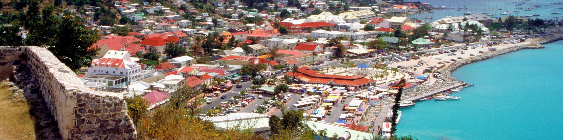 A coastal town with a historic fort, vibrant buildings, and a marina.