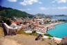 A coastal town with a historic fort, vibrant buildings, and a marina.
