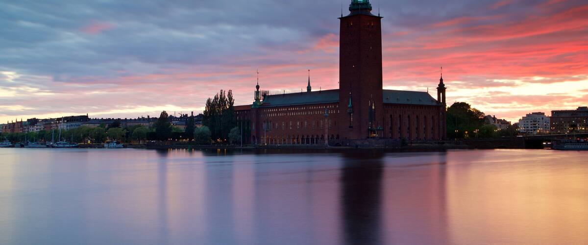 Stockholm City Hall featuring a bay or harbor, a sunset and landscape views