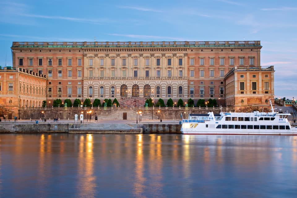 Un edificio histórico grande con una fachada imponente y un río al frente.