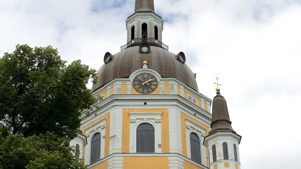 Una iglesia con un reloj, una cúpula y un campanario.