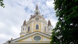 Une église dotée d’une horloge, de coupoles et d’une croix au sommet.