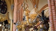 A golden statue of a knight on horseback in a cathedral.