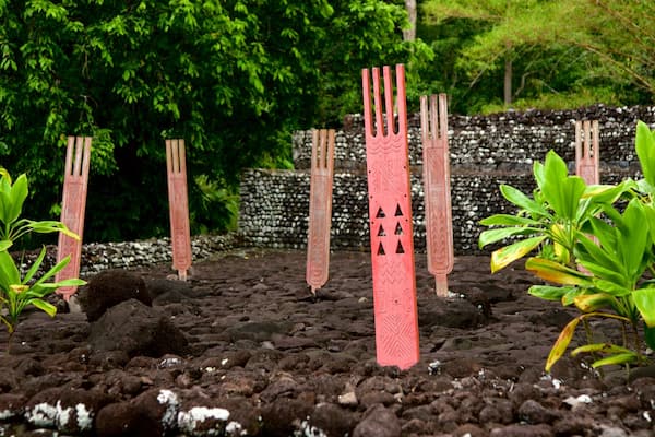 A garden with red sculptures and green plants.