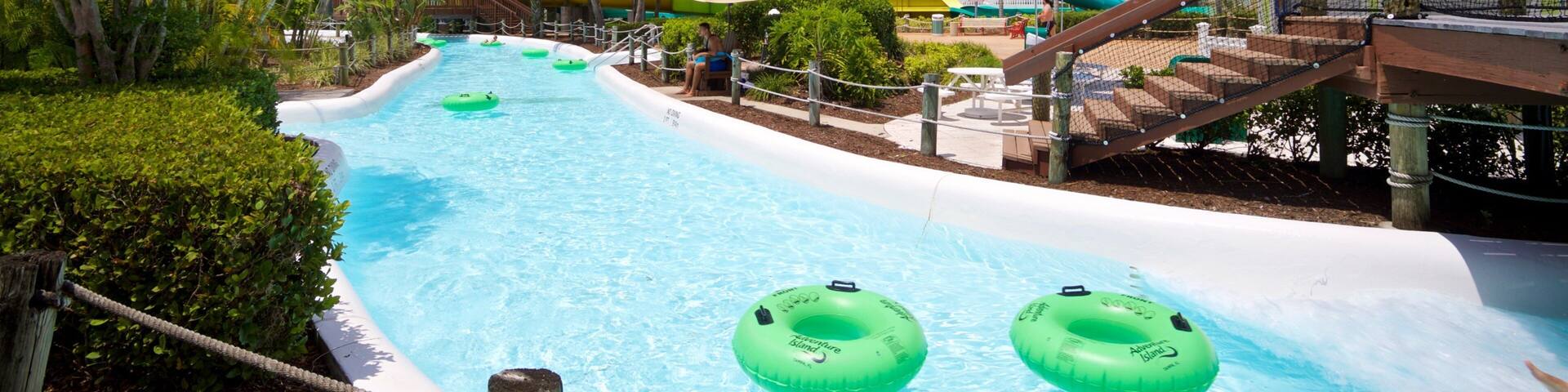 A water park with a large pool, water slides, and inflatable rings.