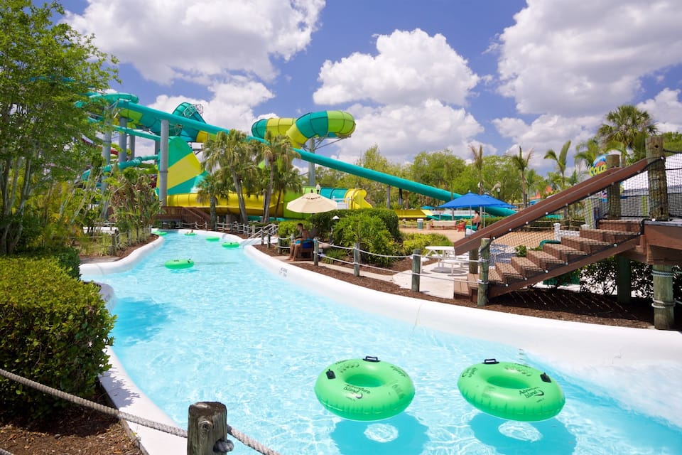 Ein Wasserpark mit großem Pool, Wasserrutschen und aufblasbaren Ringen.